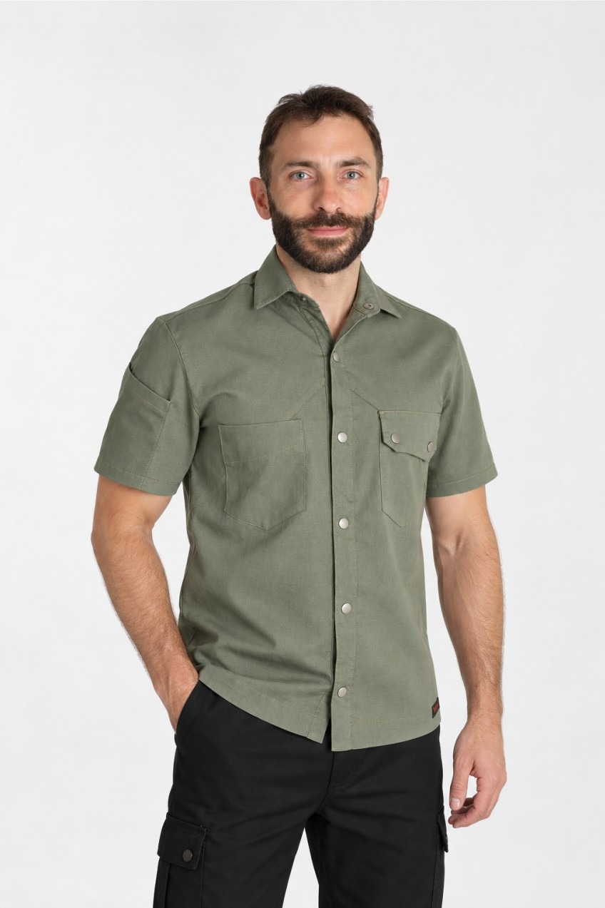Modelo de perfil con camisa Eddie de hombre en verde oliva, manga corta y bolsillos asimétricos — Songs For Uniform.